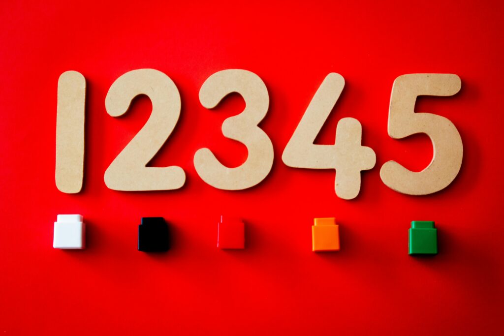 Wooden numbers and colored blocks on a vibrant red background, ideal for educational themes.