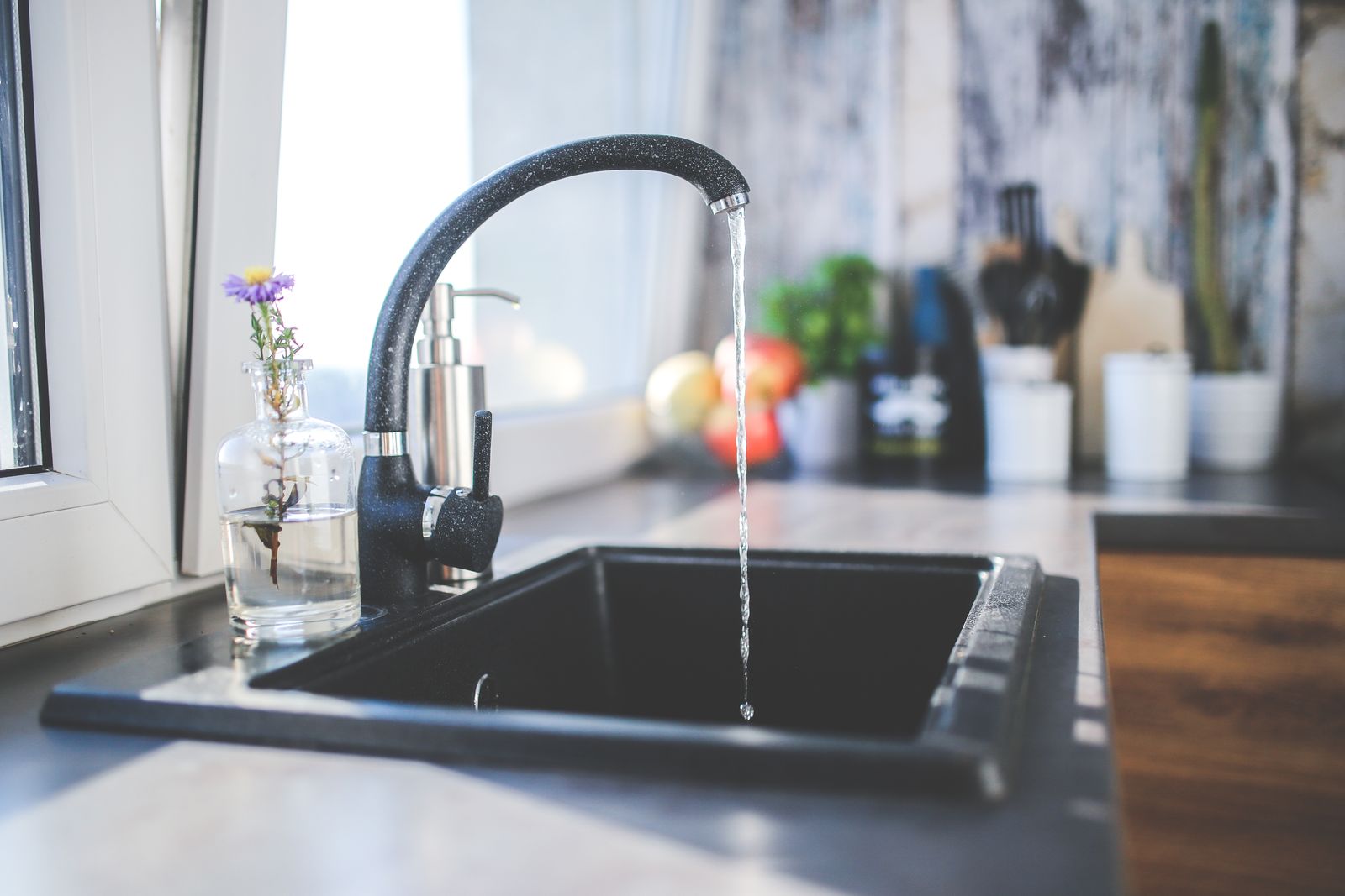 Modern kitchen sink with running tap water and a sleek chrome faucet