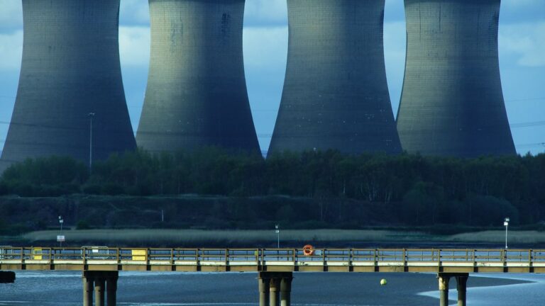 AI data centers and your water supply industrial cooling towers releasing steam representing the connection between data center cooling and water use
