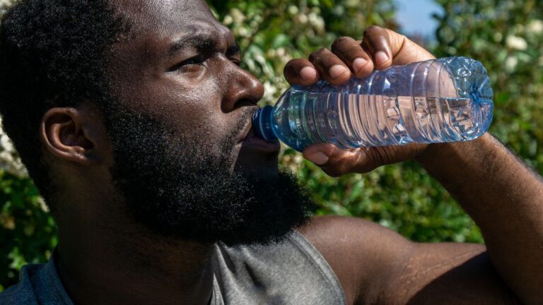 man drinking filtered water outdoors for weight loss and hydration