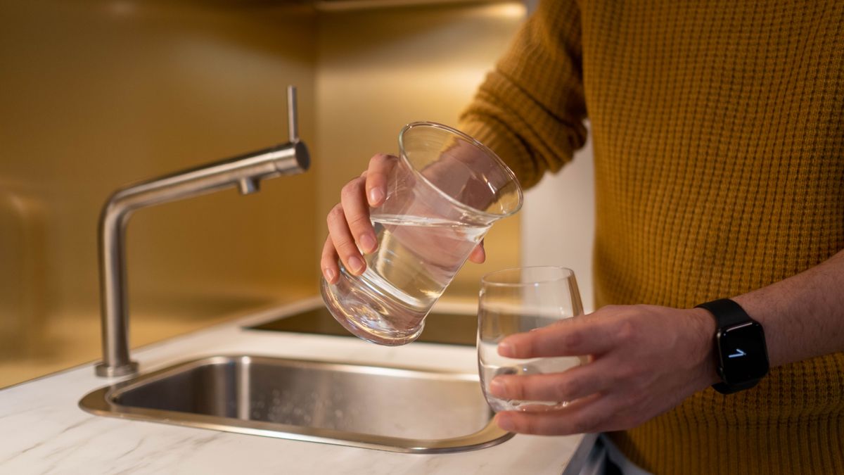 Glass being filled at a kitchen sink during National Water Quality Month